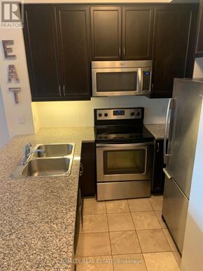Toronto (Waterfront Communities) condo for rent - A kitchen with a stove, oven, microwave, and refrigerator.