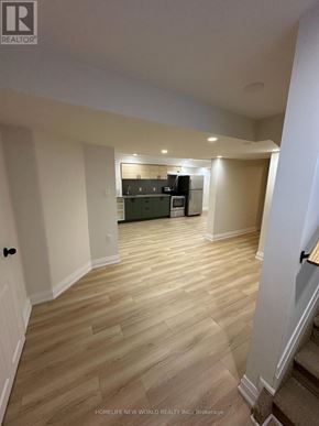 Barrie (Painswick South) apartment for rent - A room with wooden flooring and a kitchen area in the background.