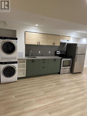 Barrie (Painswick South) apartment for rent - A modern kitchen with wooden floors and green cabinets.