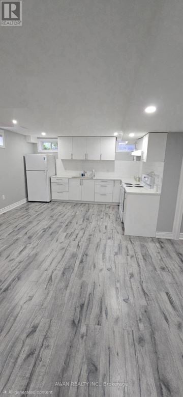 Bradford West Gwillimbury (Bradford) apartment for rent - A spacious kitchen with white cabinets and a refrigerator.