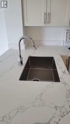 Toronto (Moss Park) condo for rent - A sink in a marble countertop with a chrome faucet.