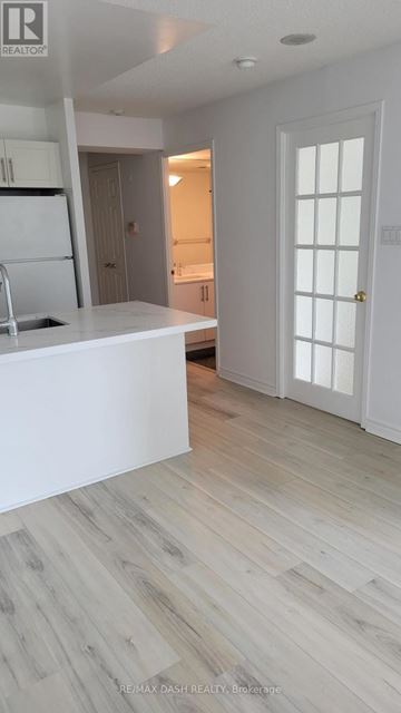 Toronto (Moss Park) condo for rent - A white kitchen with a refrigerator and sink.