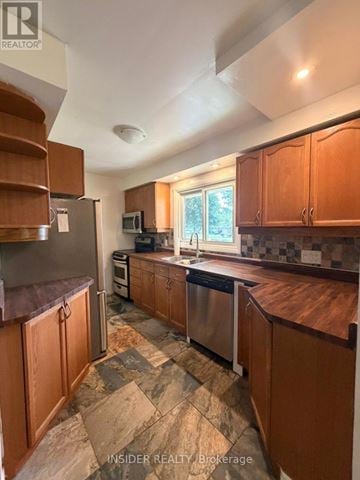 London East (East D) apartment for rent - A kitchen with wooden cabinets and a stone floor.