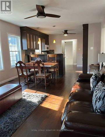 Toronto (West Hill) apartment for rent - A living room with a brown leather couch and a dining table with chairs.
