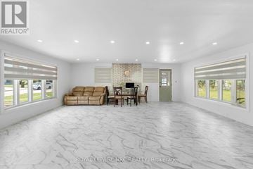 Hamilton (Kentley) apartment for rent - A spacious living room with a fireplace and a dining table set up.