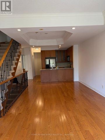 Toronto (Willowdale East) townhouse for rent - A spacious living room with hardwood floors and a staircase with a metal railing.