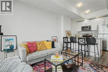 Kitchener condo for rent - A living room with a grey couch and a glass coffee table.