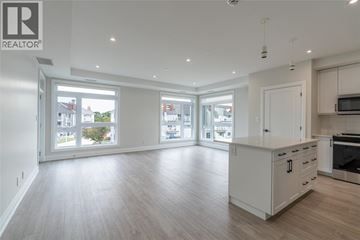 Point Edward apartment for rent - A spacious kitchen with white cabinets and a wooden floor.