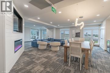 Point Edward apartment for rent - A living room with a grey carpet and a wooden dining table.