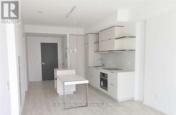Toronto (Church-Yonge Corridor) condo for rent - A white kitchen with a table and chairs.
