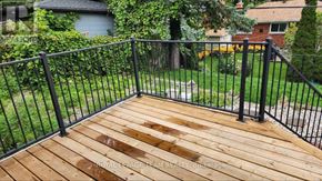 Ottawa apartment for rent - A wooden deck with a black railing.