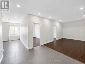 Bradford West Gwillimbury (Bradford) apartment for rent - A spacious room with white walls and wooden flooring.