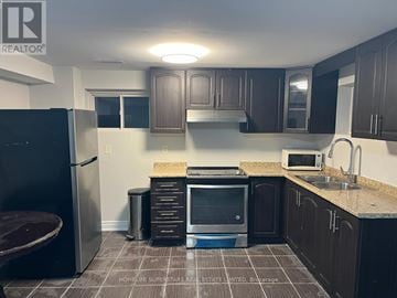 Brampton (Madoc) apartment for rent - A kitchen with a refrigerator, microwave, and sink.