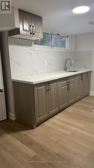 Toronto (Cliffcrest) apartment for rent - A kitchen with wooden cabinets and a marble countertop.