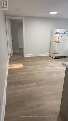 Toronto (Cliffcrest) apartment for rent - A white fridge in a room with wooden floors and white walls.