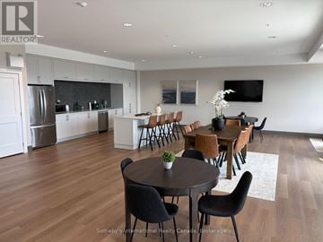 Collingwood condo for rent - A modern kitchen with a dining table set up with chairs.