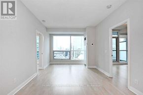 Toronto (Waterfront Communities) condo for rent - A spacious, empty room with a view of the city through a large window.