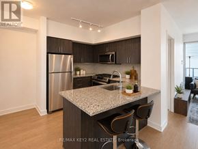 Toronto (Mimico) condo for rent - A modern kitchen with a granite countertop and stainless steel appliances.