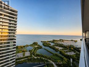Toronto (Mimico) condo for rent - A view from a high-rise building looking out over a waterfront with a moon visible in the sky.