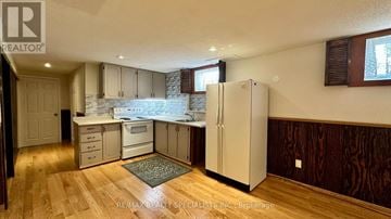 Mississauga (Erin Mills) apartment for rent - A kitchen with wooden floors and a white refrigerator.