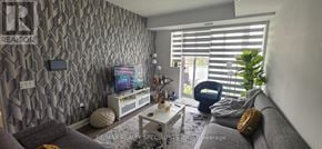 Oakville (Jm Joshua Meadows) condo for rent - A living room with a grey couch and a television.