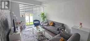 Oakville (Jm Joshua Meadows) condo for rent - A living room with a grey couch and a glass table.