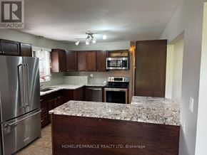 Oshawa (Donevan) apartment for rent - A kitchen with a refrigerator, microwave, and oven.