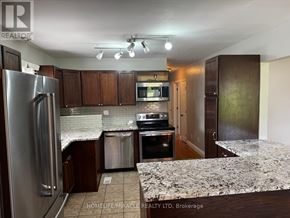 Oshawa (Donevan) apartment for rent - A kitchen with a refrigerator, stove, and microwave.
