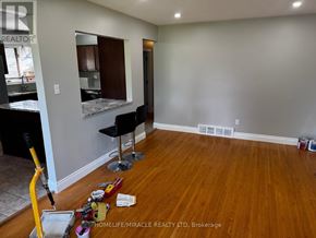 Oshawa (Donevan) apartment for rent - A room with a wooden floor and a chair in it.