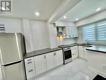 Toronto (Corso Italia-Davenport) apartment for rent - A modern kitchen with white cabinets and a stainless steel refrigerator.