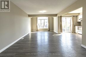 Waterloo townhouse for rent - A spacious room with wooden flooring and large windows.