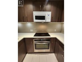 Vancouver apartment for rent - A kitchen with a white microwave above a stove and a stainless steel oven below it.