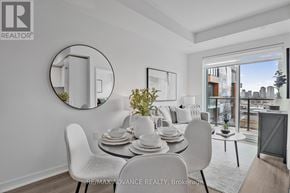 Toronto (Parkwoods-Donalda) townhouse for rent - A dining room with a white table and chairs, a round mirror, and a view of the city.