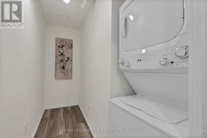 Mississauga (City Centre) condo for rent - A white bathtub in a bathroom with wooden flooring and a floral picture on the wall.