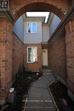 Guelph (Kortright East) townhouse for rent - A brick archway leads to a white door.