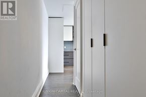 Toronto (Annex) condo for rent - A hallway with a door on the left and a wall on the right.