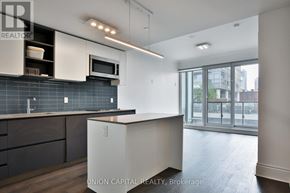 Toronto (Annex) condo for rent - A kitchen with a white counter top and a black tile backsplash.