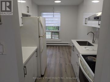 Toronto (Tam O'shanter-Sullivan) townhouse for rent - A kitchen with a white fridge and wooden floors.