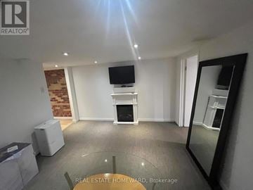 Toronto (Birchcliffe-Cliffside) apartment for rent - A living room with a flat screen TV mounted on the wall and a fireplace in the center.