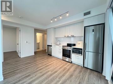 Vaughan (Vaughan Corporate Centre) condo for rent - A kitchen with white cabinets and stainless steel appliances.