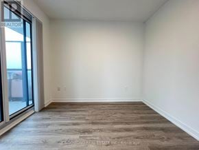 Vaughan (Vaughan Corporate Centre) condo for rent - A room with a wooden floor and a sliding glass door.