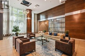 Mississauga (Port Credit) condo for rent - A living room with brown furniture and a large window.