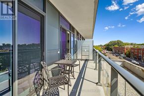 Mississauga (Port Credit) condo for rent - A balcony with a table and chairs overlooking a street.