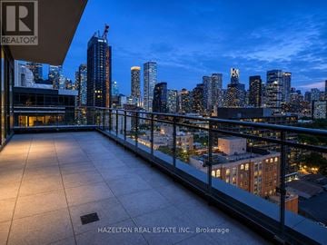 Toronto (Moss Park) condo for rent - A balcony overlooks a city skyline at dusk.