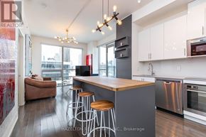 Toronto (Moss Park) condo for rent - A modern kitchen with a bar stool and a large island.