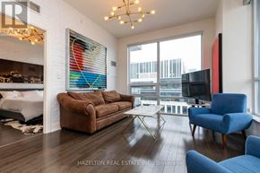 Toronto (Moss Park) condo for rent - A living room with a brown couch and a blue chair.