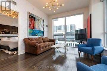 Toronto (Moss Park) condo for rent - A living room with a brown couch and a blue chair.