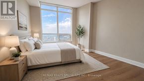 Mississauga (City Centre) condo for rent - A bedroom with a large bed and a view of the city.