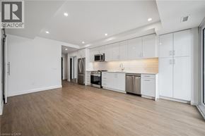 Waterloo condo for rent - A spacious kitchen with white cabinets and stainless steel appliances.