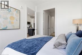 Waterloo condo for rent - A bedroom with a large bed and a painting on the wall.